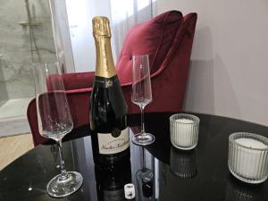 a bottle of champagne and two wine glasses on a table at Secret Room Spa Agde in Agde
