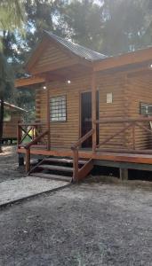 Cabaña de madera con porche y porche en Cabañas Los Aires San Vicente en San Vicente