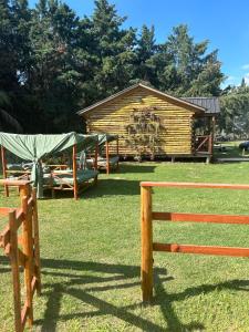 una valla de madera frente a una cabaña de madera en Cabañas Los Aires San Vicente en San Vicente