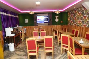 a restaurant with wooden tables and chairs and a tv at Hotel Pathibhara in Tāplejung