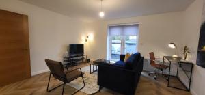 a living room with a couch and chairs and a television at Hybrid Resi - Mitcham close to Tooting and Wimbledon in Mitcham