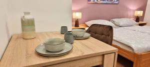 a table with two cups and plates on it with a bed at Lighthouse Zadar Center Apartments in Zadar