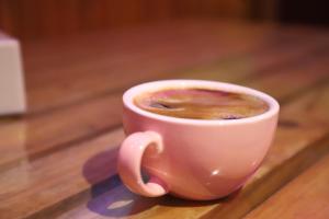 una tazza di caffè seduta su un tavolo di legno di Hotel Pathibhara a Tāplejung