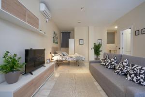 ein Wohnzimmer mit einem Sofa und einem Flachbild-TV in der Unterkunft Loft Tejares de Triana in Sevilla