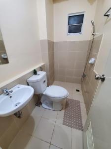 a bathroom with a toilet and a sink at COZY STUDIO DELUXE with Pool, Free Parking & Basket Ball Court , Pet Friendly Condo in Manila