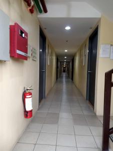 a hallway of a hospital with a fire extinguisher on the wall at COZY STUDIO DELUXE with Pool, Free Parking & Basket Ball Court , Pet Friendly Condo in Manila