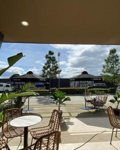a patio with a table and chairs and tables and umbrellas at HERMOSA by Crown Asia Cozy Studio with Pool, Free Parking & Basket Ball Court in Manila