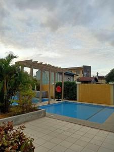 a swimming pool with a pergola next to a building at COZY STUDIO DELUXE with Pool, Free Parking & Basket Ball Court , Pet Friendly Condo in Manila