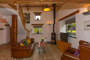 a living room with a couch and a tv at The Old Cowshed Haverfordwest in Haverfordwest