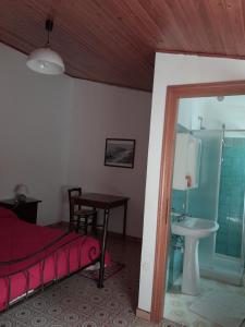 a bedroom with a bed and a sink and a table at Antichi Sapori da Speranza in Gavoi