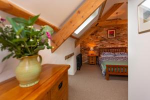 a vase of flowers on a dresser in a bedroom at The Old Cowshed Haverfordwest in Haverfordwest