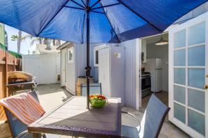 Ocean Beach Cottage في سان دييغو: طاولة مع مظلة زرقاء على الفناء