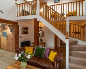 a living room with a couch and a staircase at The Old Cowshed Haverfordwest in Haverfordwest