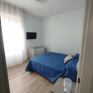 a bedroom with a blue bed and a television at Onda Marina 2 in La Spezia