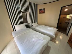 帕幹島的住宿－Soukaina Beach Bungalow，配有白色床单的酒店客房内的两张床