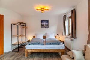 um quarto com uma cama e uma estante de livros em Ferienwohnung Leberkas Hotspot 1og em Ehrwald