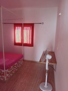 Habitación pequeña con cama y ventilador. en L'essentiel nianing, en Mbour