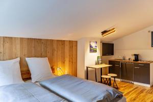 une chambre d'hôtel avec un lit et une cuisine dans l'établissement Ferienwohnung Leberkas Hotspot 2og, à Ehrwald