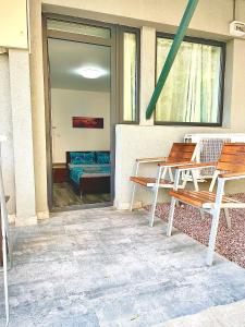 a patio with two benches and a table and a couch at Quantum villa in Neptun