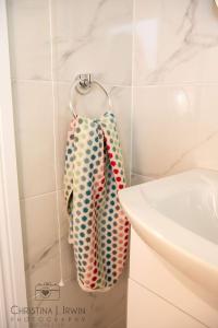 un baño con 2 pijamas colgando de un perchero en The Snug, en Donegal