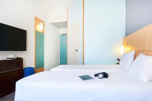 Rúm í herbergi á Ibis Como