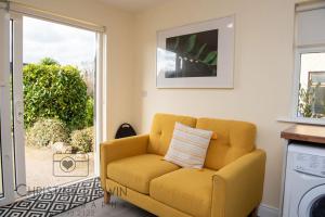 un sofá amarillo en una sala de estar con ventana en The Snug, en Donegal