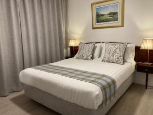 a bedroom with a large bed with two lamps at Cille Apartments, Ballyferriter village in Ballyferriter