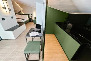 Habitación con pared de acento verde, escritorio y cama en Amamare Luxury Room, en Giulianova