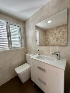 a bathroom with a toilet and a sink and a mirror at Villa Benicassim Eurosol REF. 028 in Benicàssim