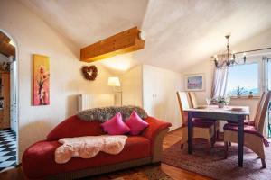 - un salon avec un canapé rouge et des oreillers roses dans l'établissement Ferienwohnung Fitzek, à Seeg