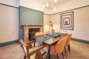une salle à manger avec une table, des chaises et une cheminée dans l'établissement Host & Stay - Kittiwake House, à Whitley Bay