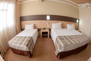 Postel nebo postele na pokoji v ubytování Hotel Executive Arapongas