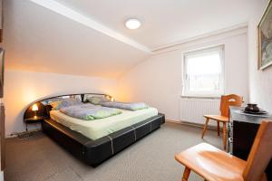 1 dormitorio con cama, escritorio y ventana en Haus am Wald en Bad Koetzting