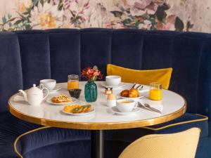 パリにあるホテル ル マレイユの食べ物と飲み物の盛り合わせが付いたテーブル