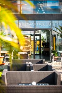 a building with tables and chairs in front of it at BL Apartman by HelloBalatonlelle in Balatonlelle