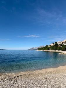 einen Strand mit blauem Wasser und felsiger Küste in der Unterkunft Apartman Royal Lino in Baška Voda