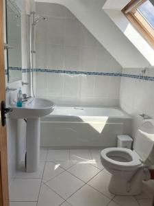 a white bathroom with a sink and a toilet at 1 Bray Head View in Portmagee