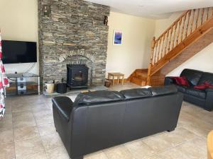 a living room with a couch and a stone fireplace at 1 Bray Head View in Portmagee