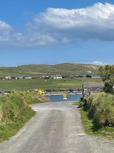 a dirt road with signs on the side of a river at 1 Bray Head View in Portmagee