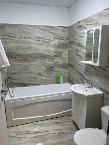 a bathroom with a bath tub and a sink at Pollux Residence Militari ap 84 in Dudu