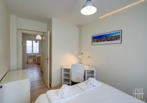 una camera bianca con letto e scrivania di Le Catalane a Tours