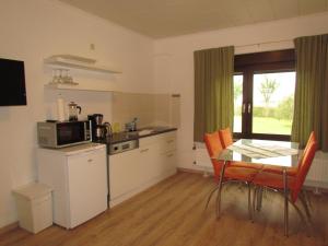 une cuisine avec une table, une table et un four micro-ondes dans l'établissement Ferienhof Gliesner, à Usedom Town