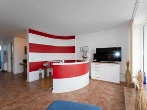 een woonkamer met een rode en witte muur bij 033 Arngast Ferienwohnung in Wilhelmshaven