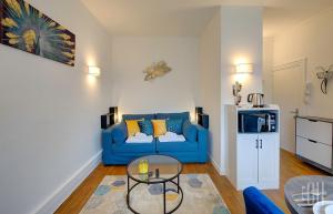 uma sala de estar com um sofá azul e uma mesa em Le Mirabeau / Proche Gare em Saint-Pierre-des-Corps