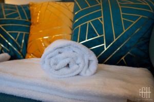 a towel sitting on top of a bed with pillows at L'Agapanthe - Proche Gare in Saint-Pierre-des-Corps