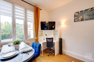 a room with a table and chairs and a desk at L'Agapanthe - Proche Gare in Saint-Pierre-des-Corps +4 photos