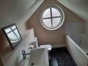 a bathroom with a sink and a round window at Stunning 5-bed ensuite House Solihull in Solihull