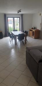 a living room with a table and chairs and a couch at appartement Courcelles in Courcelles