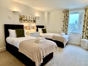 een slaapkamer met 2 bedden en een raam bij Your Space Apartments - The Hamilton's in Cambridge