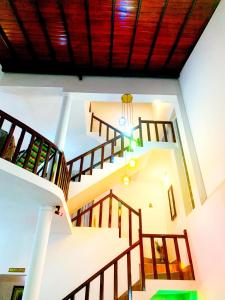 a staircase in a house with wooden railings at Matara Near Polhena & Mirissa Three Story House in Matara